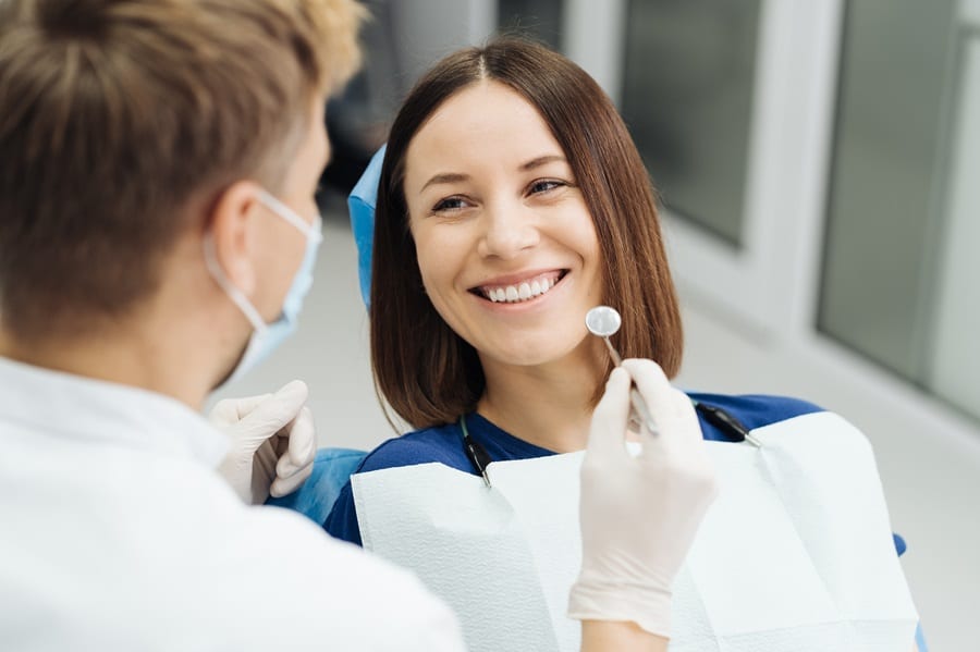 dentista che esamina paziente pulizia sbiancamento denti