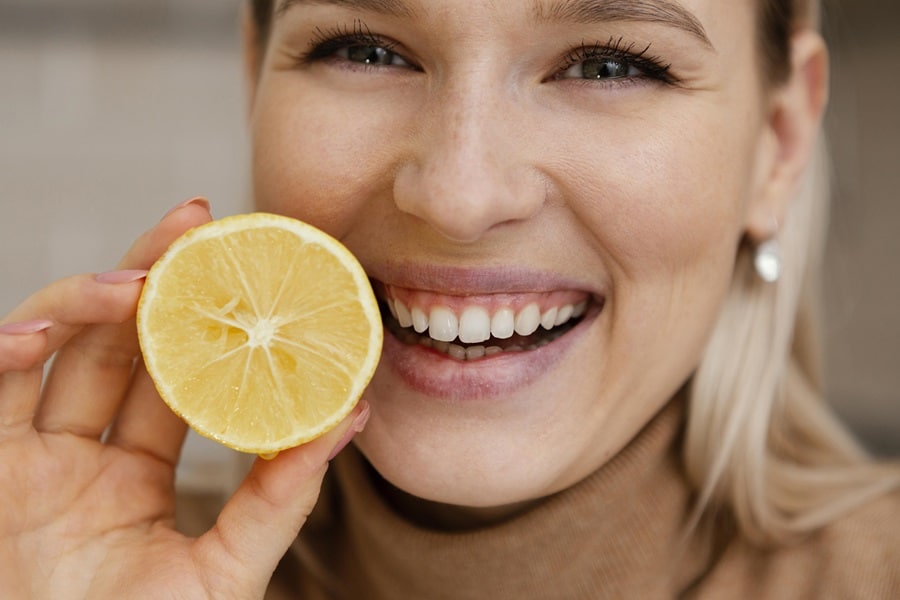 donna sorridente che tiene in mano un limone